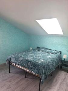 a bedroom with a bed in a blue wall at Le Galaveyson in Saint-Clair-sur-Galaure