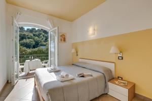 a bedroom with a large bed and a balcony at Seaview Pool Retreat - Il Poggio in Marina di Andora +291 photos