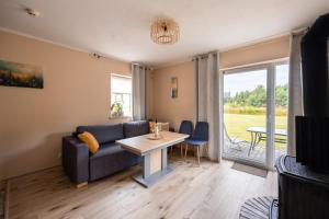 a living room with a couch and a table at Mazurski domek in Mrągowo