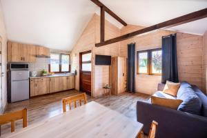 a kitchen and a living room with a table at Mazurski domek in Mrągowo