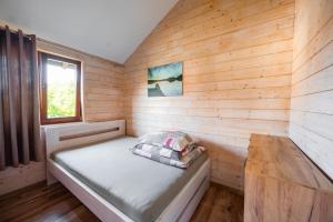 a small room with a bed and a window at Mazurski domek in Mrągowo