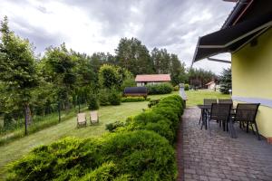 a patio with chairs and a table in a garden at Mazurski domek in Mrągowo