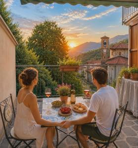a man and a woman sitting at a table on a balcony at San Marco Panorama Apartment in Torre deʼ Busi