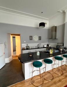 a kitchen with a counter and some green bar stools at Prime location Clifton 2 bed self contained spacious garden apartment in Bristol
