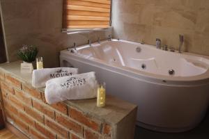 a bathroom with a tub and towels and candles at Mount House Lodge in Guano +117 photos