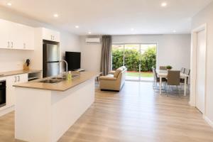 a kitchen with a counter top and a living room at 20 Pimpama Home in Pimpama