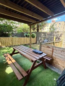 a wooden picnic table sitting under a pavilion at Prime location Clifton 2 bed self contained spacious garden apartment in Bristol