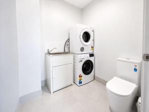 a laundry room with a washing machine and a washer at 20 Pimpama Home in Pimpama