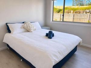 a bedroom with a bed with a teddy bear on it at 20 Pimpama Home in Pimpama
