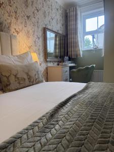 a bedroom with a large bed and a window at The Blue Bell Inn in Weaverthorpe
