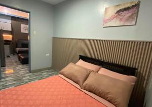 a bedroom with a bed with an orange blanket at Amplayo Apartelle 2-BR Unit in Cagayan de Oro
