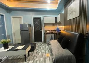 a living room with a couch and a kitchen at Amplayo Apartelle 2-BR Unit in Cagayan de Oro