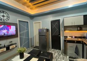a kitchen with a refrigerator and a tv on a wall at Amplayo Apartelle 2-BR Unit in Cagayan de Oro