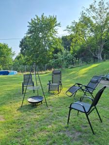 a group of chairs and a swing in the grass at Apartament Alicja in Chmielno +6 photos