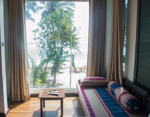 a living room with a couch and a large window at Ripple Beach Inn in Hulhumale