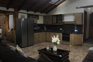 a kitchen with a refrigerator and a table with flowers on it at Mount House Lodge in Guano
