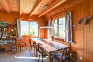 a dining room with a wooden table and chairs at Les Jumelles in Rougemont +11 photos