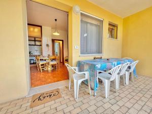 a dining room with a blue table and white chairs at Quarzo e Acquamarina in Lido Adriano