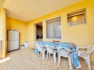 a dining room with a table with chairs and a window at Quarzo e Acquamarina in Lido Adriano