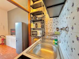 a kitchen with a sink and a refrigerator at Quarzo e Acquamarina in Lido Adriano +21 photos