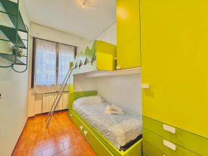 a small room with a bed with a yellow wall at Quarzo e Acquamarina in Lido Adriano