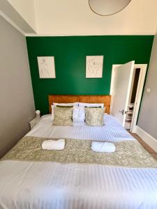a bedroom with a large bed with a green wall at Prime location Clifton 2 bed self contained spacious garden apartment in Bristol