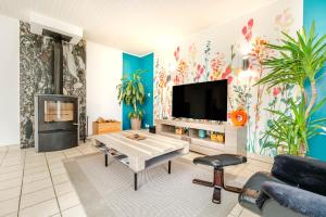 a living room with a tv and a table at La Maison de Rolie in Plévin
