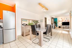 a kitchen and dining room with a table and chairs at La Maison de Rolie in Plévin +15 photos