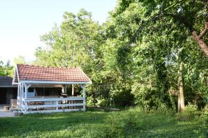 a white gazebo with a red roof in a yard at Ana apartmani in Pačir