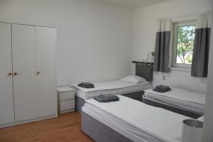 a room with three beds and a window at Ana apartmani in Pačir