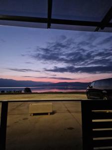 a bench in a parking lot with a view of the ocean at Apartment Dalas 2 Star Dojran in Star Dojran