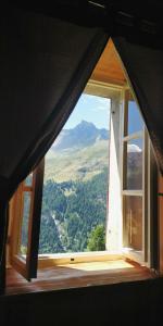 an open window with a view of a mountain at Locanda Teggiate in Madesimo
