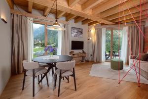 a dining room with a table and chairs and a television at LVG Hotel Collection - Cascata d'Otro Mountain Lodge in Alagna Valsesia