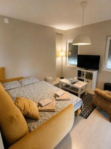 a bedroom with a bed and a living room at Vila Bilja in Požega