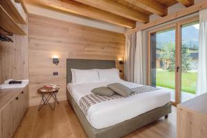a bedroom with a bed and a large window at LVG Hotel Collection - Cascata d'Otro Mountain Lodge in Alagna Valsesia