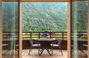 a table and chairs on a balcony with a view at LVG Hotel Collection - Cascata d'Otro Mountain Lodge in Alagna Valsesia