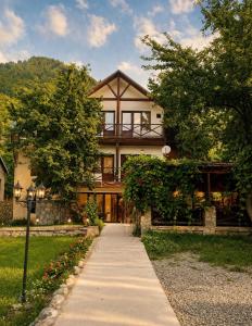 a large house with a walkway in front of it at Hotel Chubu in Mestia
