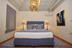 Un dormitorio con una cama grande con cabecero azul. en Fisherman's Cottage, en Kalamakia