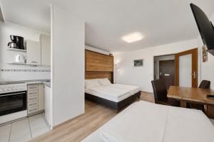 a small apartment with a bed and a dining room at Kaprun Apartments in Kaprun