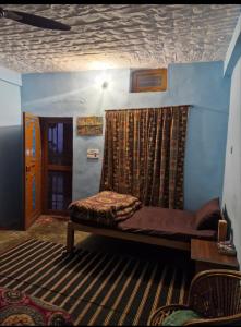 a room with a bed and a window with a curtain at Far out Homestay in Hawālbāgh +28 photos
