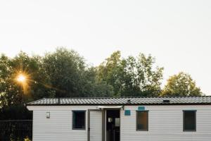 a white house with a door and trees at Tiny House Kleinrettbach 
