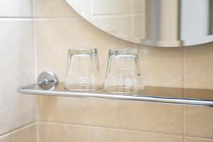 two glasses sitting on a shelf in a bathroom at Hotel Ferum in Šaca +87 photos