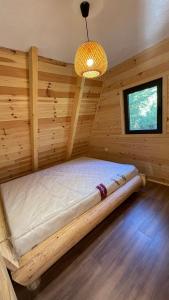 a bed in a log cabin with a chandelier at Vila Caričić Žabljak in Žabljak
