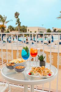 マルサラにあるDelfino Beach - CDSHotelsのビーチに置かれた食べ物と飲み物が並んだテーブル