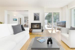 a living room with a white couch and a fireplace at Hohrott 17 Villa Bellevue I in Heikendorf