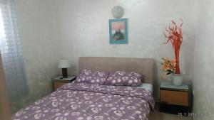 a bedroom with a bed with a purple comforter at Kuća Vranića,Sevojno in Ðurovići