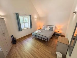 a bedroom with a bed with two lamps on it at Maple Lodge Cottage in Blagdon