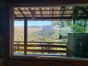 a window with a view of a mountain view at Vila Literária Tabuleiro in Conceição do Mato Dentro