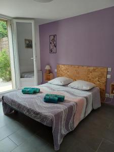 a bedroom with a bed with two green pillows on it at Paisible T2 climatisé avec jardinet in Béziers