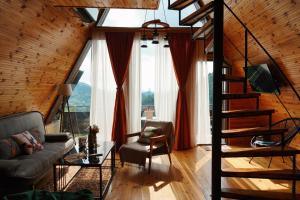 a living room with a staircase and a couch at Wayside Cottage in Batumi